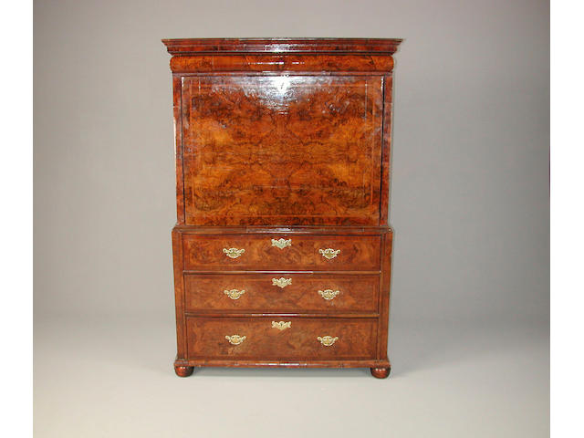 An early 18th Century walnut featherbanded escritoire, the frieze drawer above a fall front enclosing five drawers with secret pigeonholes, and recesses, above three long drawers, on bun feet minor repairs to veneering