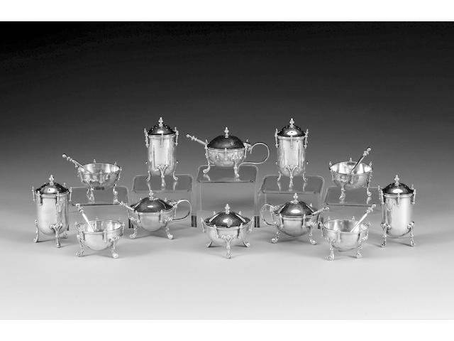 A Victorian silver set of four salts, modelled as drums, possibly by Henry Holland, London 1873, and further mustards and peppers,