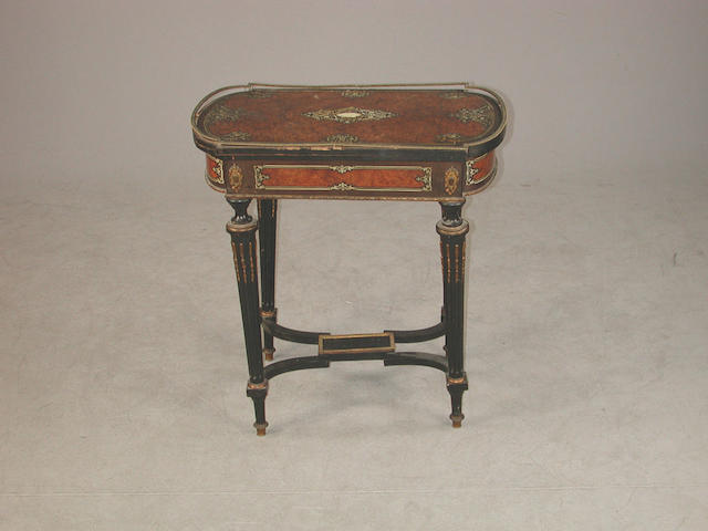 A 19th century French ebonised work table with hinged top opening to reveal three sections, inlaid with thuya wood and with ivory ma...