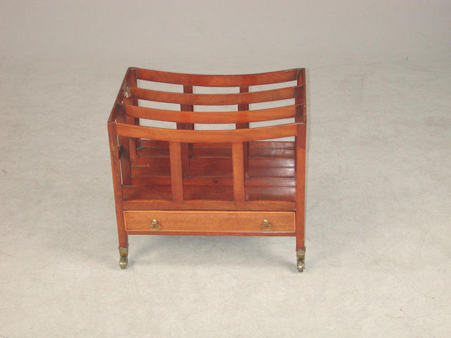 A Regency mahogany canterbury with four divisions and a boxwood banded drawer, on castors restorations, a section broken and detache...