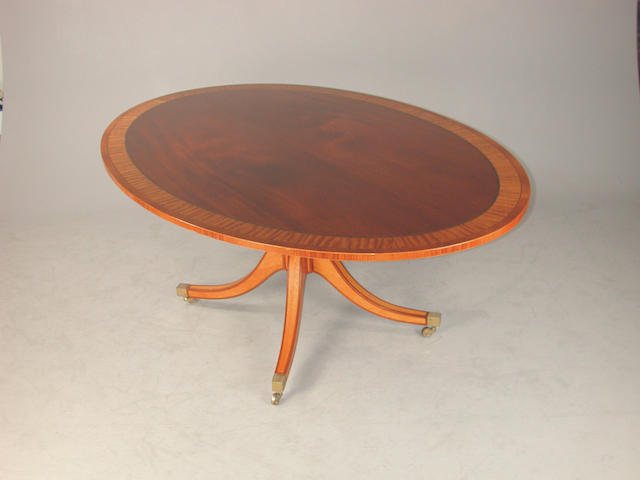 A reproduction mahogany and satin wood crossbanded oval breakfast table