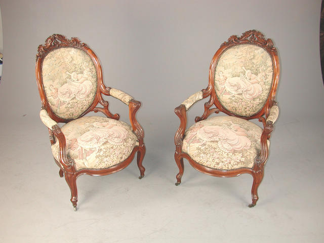 A pair of late Victorian carved mahogany armchairs, with tapestry upholstery, on cabriole legs The tapestry coverings depicting 'The Swing' by Fragonard (1776)