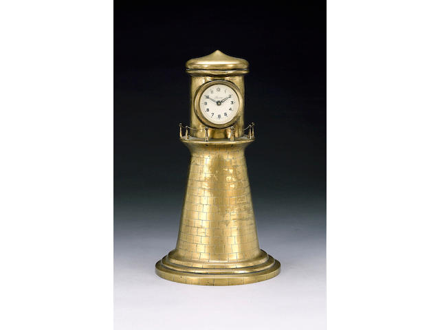 An early 20th Century brass lighthouse timepiece, the lacquered brass case in the form of a squat lighthouse to an Arabic dial to a skeletonised movement with lever escapement 31cm.