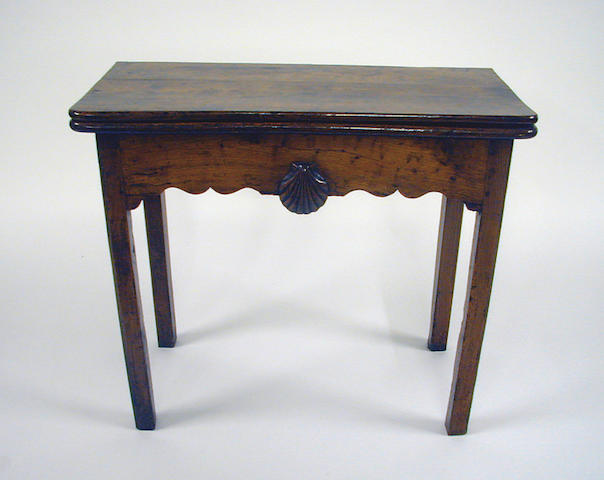 A late 18th Century fruitwood foldover card table, with counter wells to the interior and shell ornament to frieze, probably French, 83.5cm wide.