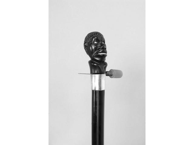 A late 19th century ebony mounted reluctant beheader gadget cane,