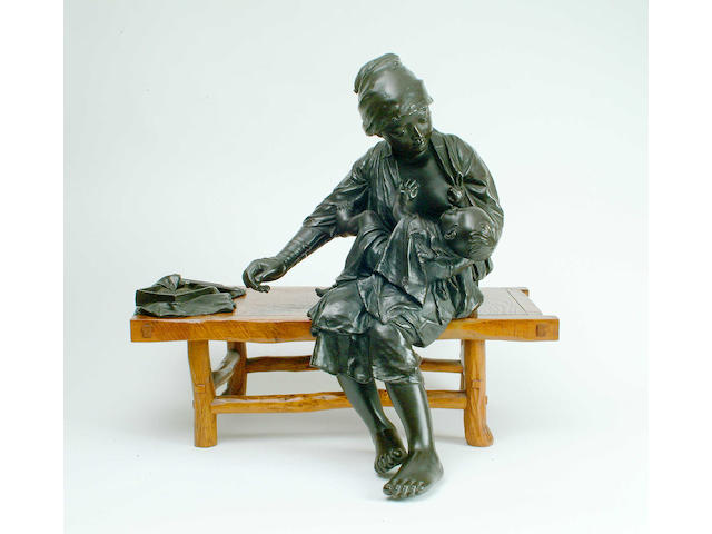 A Chinese bronze figure of a mother feeding her child