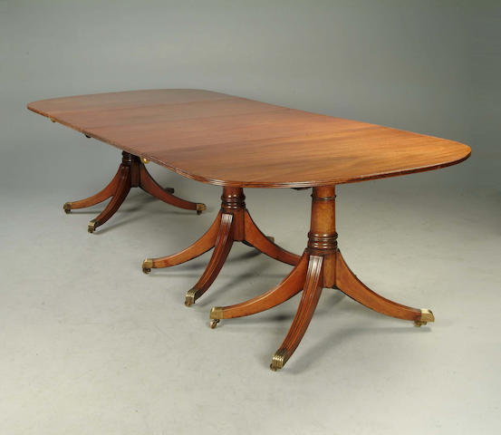 A George III style mahogany triple pedestal D end dining table