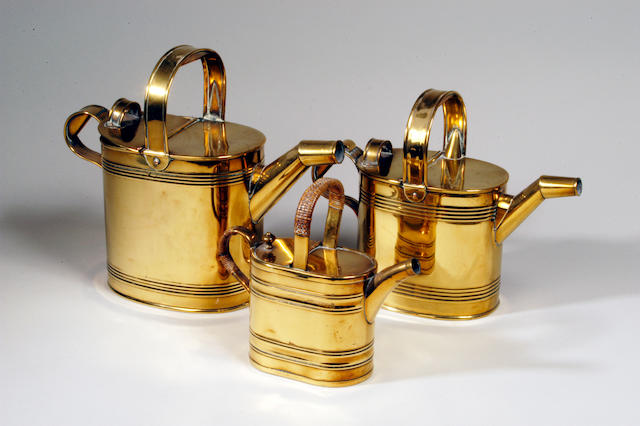 Three matched graduated oval brass watering cans,
