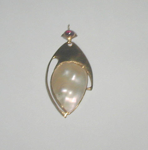 A mother of pearl and garnet pendant retailed by Liberty & Co to a design by Archibald Knox,