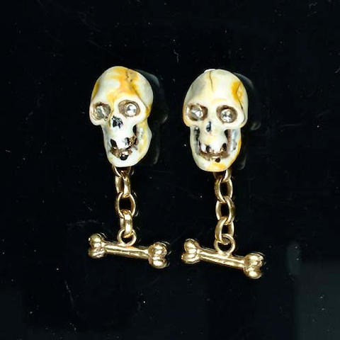 A pair of enamel and diamond skull cufflinks