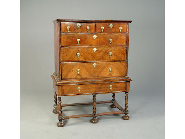 An early 18th century walnut and feather banded chest on later stand