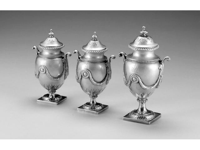 A George III suite of three silver tea caddies, by Andrew Fogelberg, large urn London 1772, one smaller London 1771, the second smaller apparently unmarked, all covers part marked with maker's mark and lion passant,
