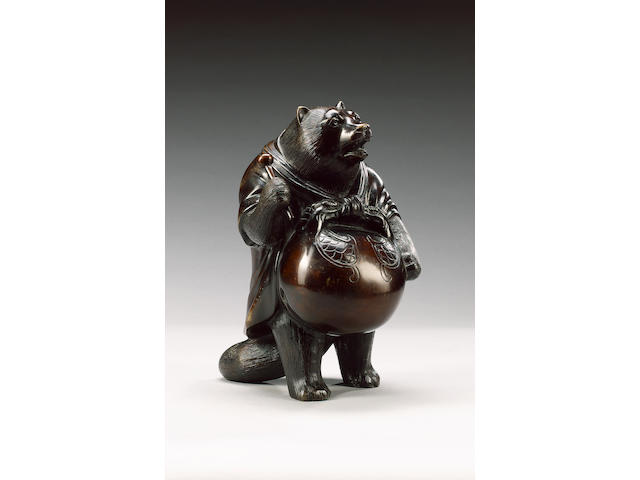 An elegant bronze figure of a standing tanuki,