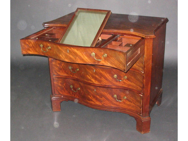 A George III figured mahogany serpentine fronted gentleman's commode,