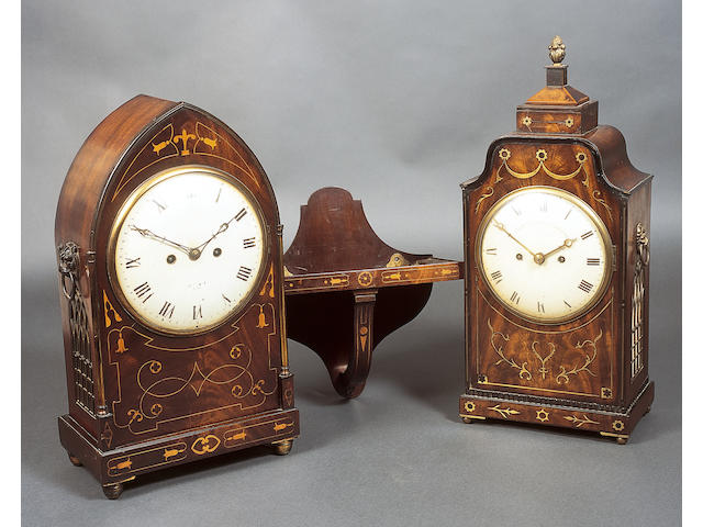 A late George III Gothic design figured mahogany, boxwood marquetry and line inlaid bracket clock, the domed and painted circular dial with eight day twin fusee striking and repeating movement, the back plate with engraved border and inscribed "Josh. Moxon, London", flanked by gilt brass turned section pilasters below a brass beaded edge top, Gothic arch glazed and gilt brass fretwork side panels, each below a patinated leopard's mask ring side handle, on a plinth base and gilt brass bun type feet, 49.5cm high, complete with original bracket with conforming inlays, 31cm high.  (2)  See illustration
