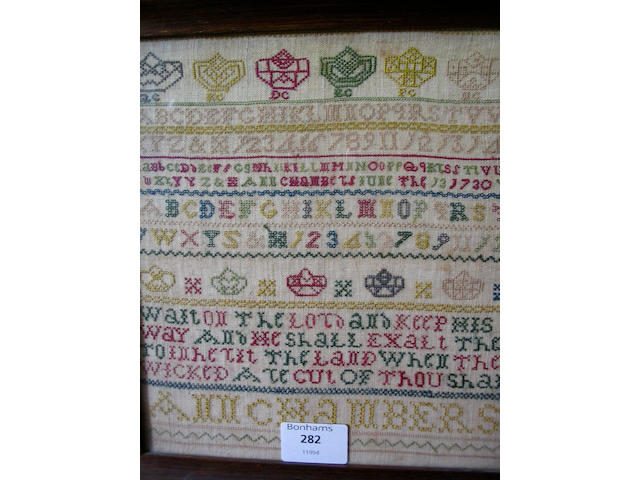 A George II sampler colourfully worked in silk threads to linen ground,