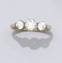 A diamond three stone ring Claw set with old brilliant-cut diamonds, principal stone approximately 0.65ct, ring size N.