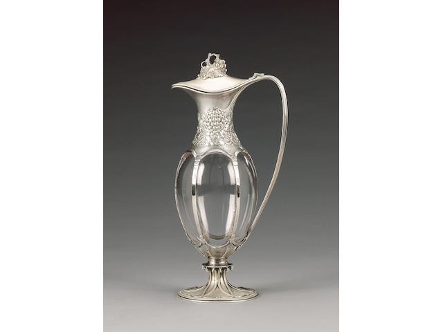 An Edwardian silver-mounted and clear glass claret jug, by Omar Ramsden & Alwyn Carr, London 1909, engraved on base "OMAR RAMSDEN ET ALWYN CARR ME FECERVNT"