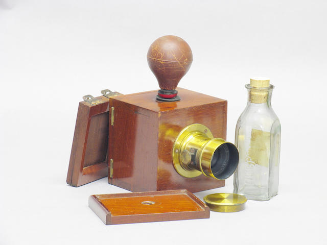 Dubroni No. 2 camera by A. Bourdin France; patented May 21 1860, for images 4.5 x 5.5cm polished wood and brass body, red glass viewing window, internal ceramic developing chamber, ground glass, maker's plate: "Appareil Dubroni Brevete SCDG A Paris 256 Rue de Rivoli", a brass bound lens engraved "Darlot Paris" with cap, pipette with rubber bulb, tripod platform, printing frame and bottle impressed "Dubroni"  (7)