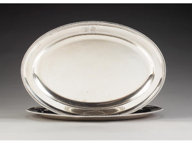 Two matched George III silver oval platters, by William Stroud, London 1804 and by William Frisbee, London 1799,