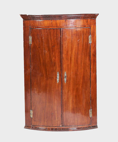 A George III mahogany bow-fronted hanging corner cupboard,