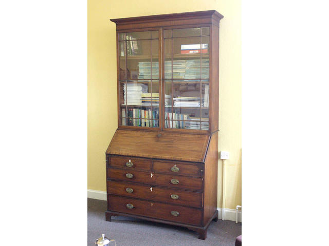 A George III mahogany and inlaid bureau with a later bookcase top,