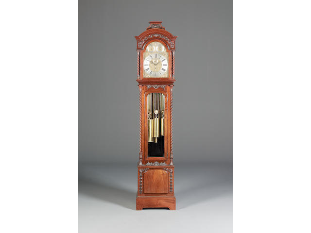 A good early 20th Century carved mahogany quarter chiming longcase clock, chiming on nine brass plated tubular chimes.
