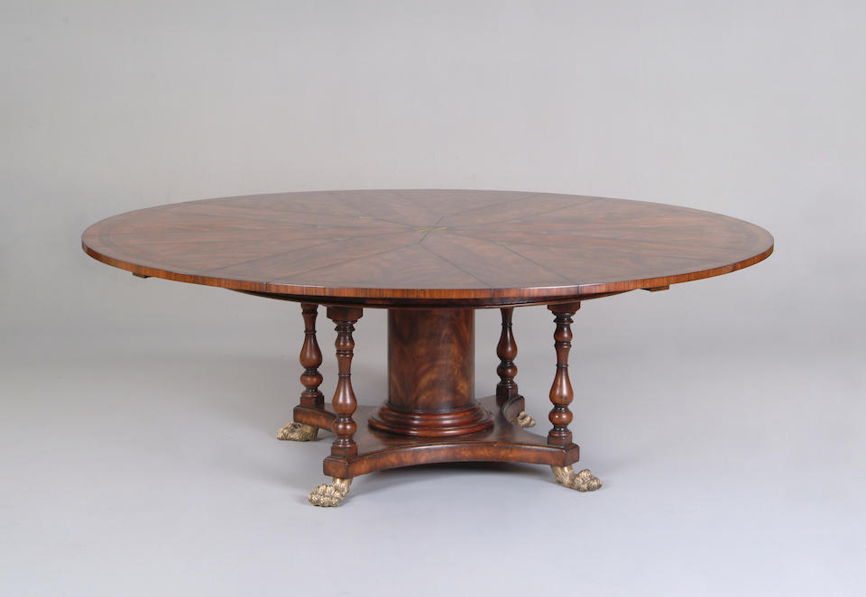 A mahogany and rosewood crossbanded extending circular dining table in the manner of Robert Jupe