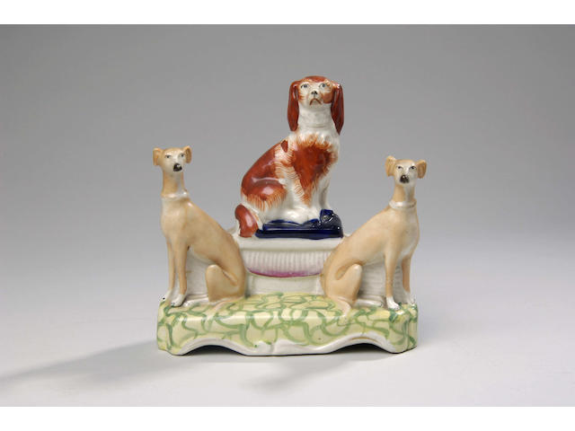 An interesting Staffordshire pottery dog group,
