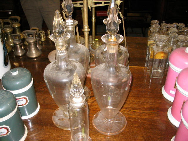 A set of four glass carboys and stoppers,