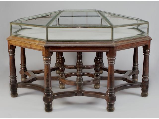 A late 19th/early 20th century octagonal museum type bevel glazed display cabinet, in the style of Sir Edwin Lutyens
