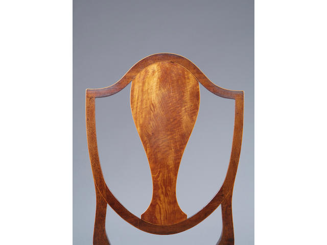 A set of eight mahogany dining chairs The shield shaped backs with solid figured splats, having drop-in seats, on tapering legs (to include one carver). (8)