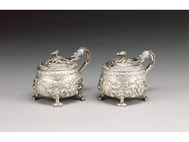 A matched pair of silver mustard pots and covers, one maker's mark SW, possibly by Samuel Wheatley, London 1817 the second by John Hunt & Robert Roskell, London 1867,
