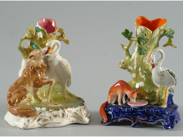 Two Staffordshire figural spill vases, one with a dog and stork, the other fox and stork