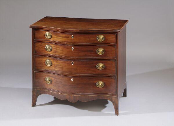 A George III mahogany serpentine chest Of four long graduated drawers with inlaid bone shield shaped lock escutcheons and oval brass plate handles, on swept bracket feet, 96cm wide.