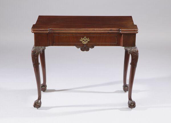 An early George III mahogany tea table The fold-over top with outset angles, fitted with a cockbeaded frieze drawer above a carved scroll motif, on cabriole legs with acanthus carved knees and ball and claw feet, 91cm wide.