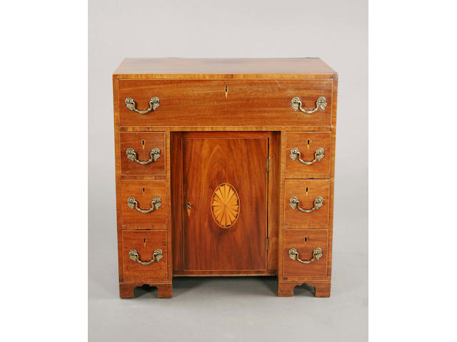 A George III mahogany and boxwood line edged kneehole desk