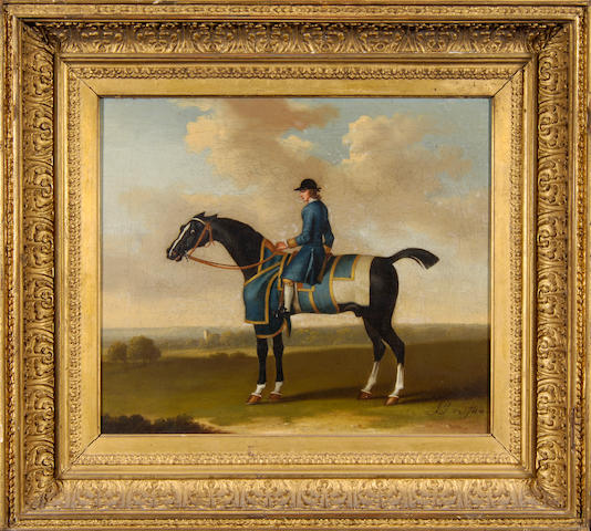 James Seymour (c.1702-1752) A black racehorse in blue exercise rugs with gold trim with jockey up, standing in an extensive landscape