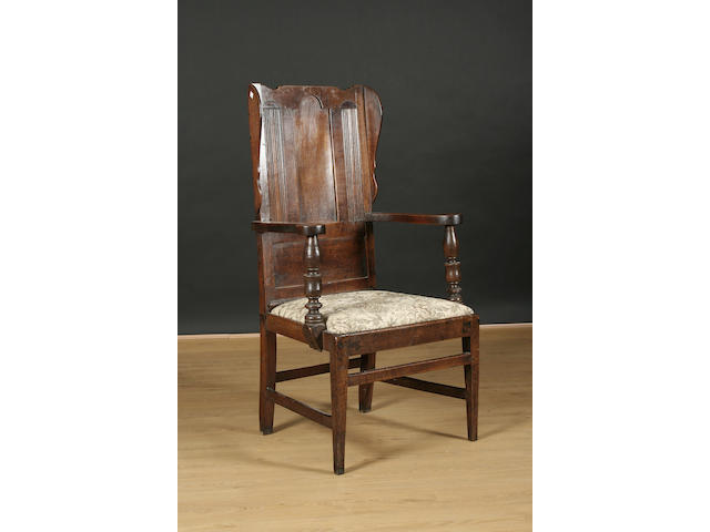 An 18th Century and later oak winged open arm chair