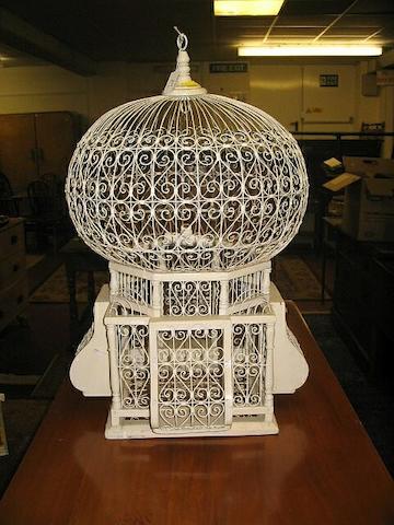 A white wooden and scrolling metal bird cage