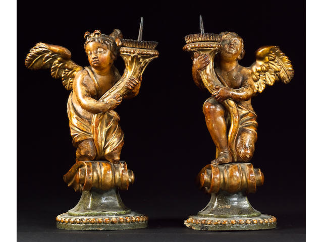 A pair of 18th century Italian giltwood and polychrome decorated candles bearing angels