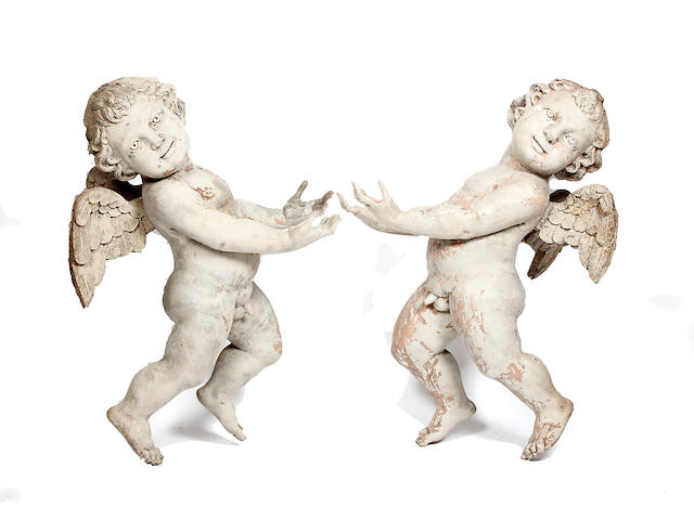 A pair of carved winged cherubs