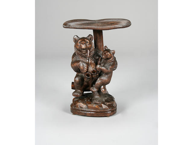 A early 20th century Swiss 'Black Forest' carved and stained wood bear smokers table