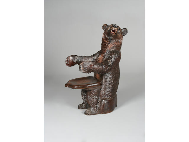 An early 20th century Swiss 'Black Forest' carved and stained wood bear armchair