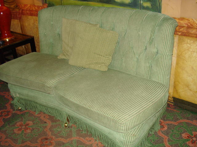 A green striped upholstered bow shaped sofa