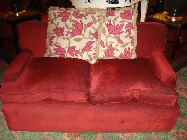 A pair of red upholstered two seater sofas