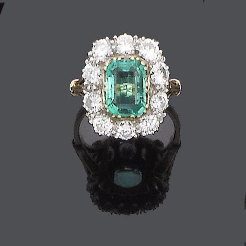 An emerald and diamond cluster ring