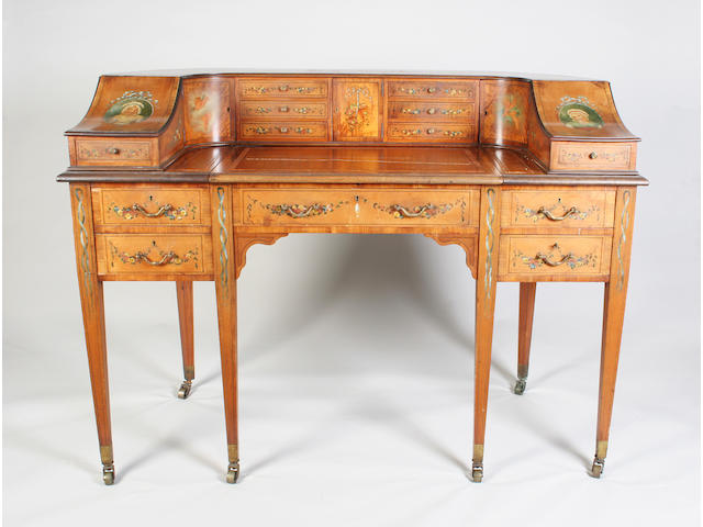 An early 20th century Sheraton revival satinwood, kingwood crossbanded, line inlaid and classical polychrome painted Carlton House desk