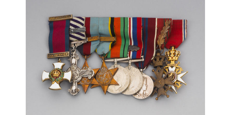 An assortment of military decorations, log books, certificates, photos, and warrants.
