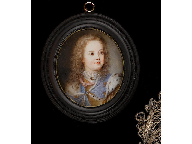 French School, circa 1715 Louis XV (1710-1774) as a child, wearing blue ermine-lined cloak embroidered with gold fleur-de-lys over white lace collar, his hair worn long and curling